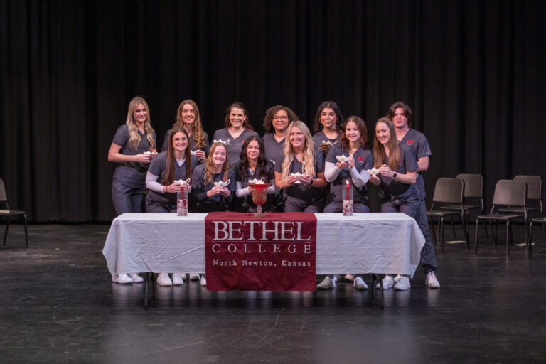 The 12 members of the nursing Class of 2025 with their lamps