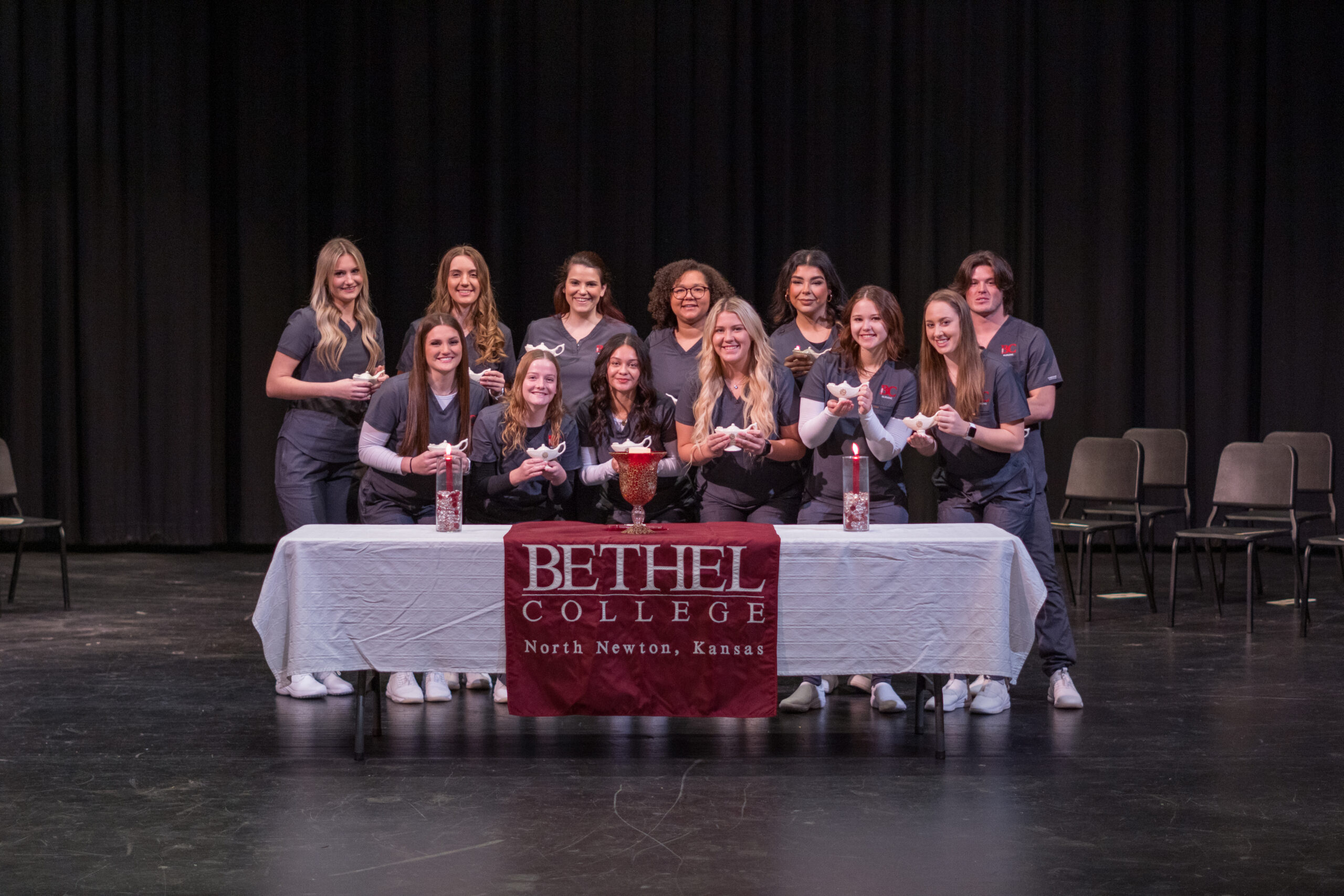 The 12 members of the nursing Class of 2025 with their lamps