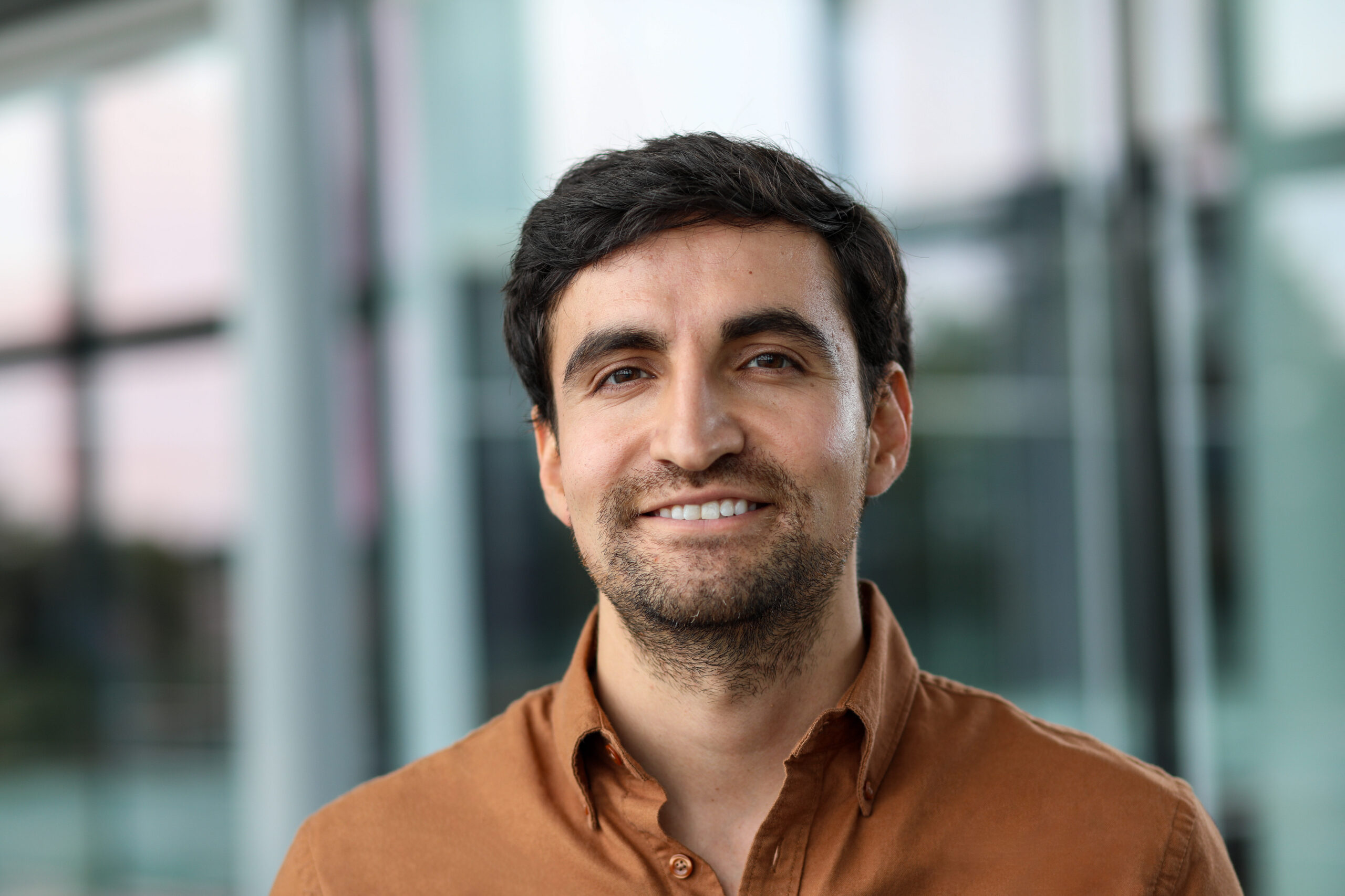 Headshot of Alvaro Morales in brown collared shirt