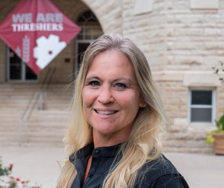 Headshot of Stacy Middleton, with the Ad Building and banner in the background