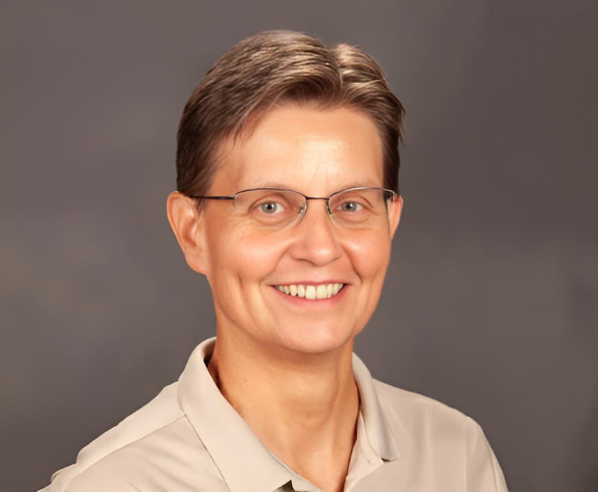 Headshot of Vicki Daniel in off-white collared shirt with neutral background