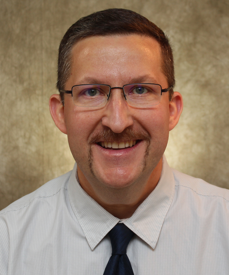 Headshot of Eric Schmaltz in white shirt and black tie