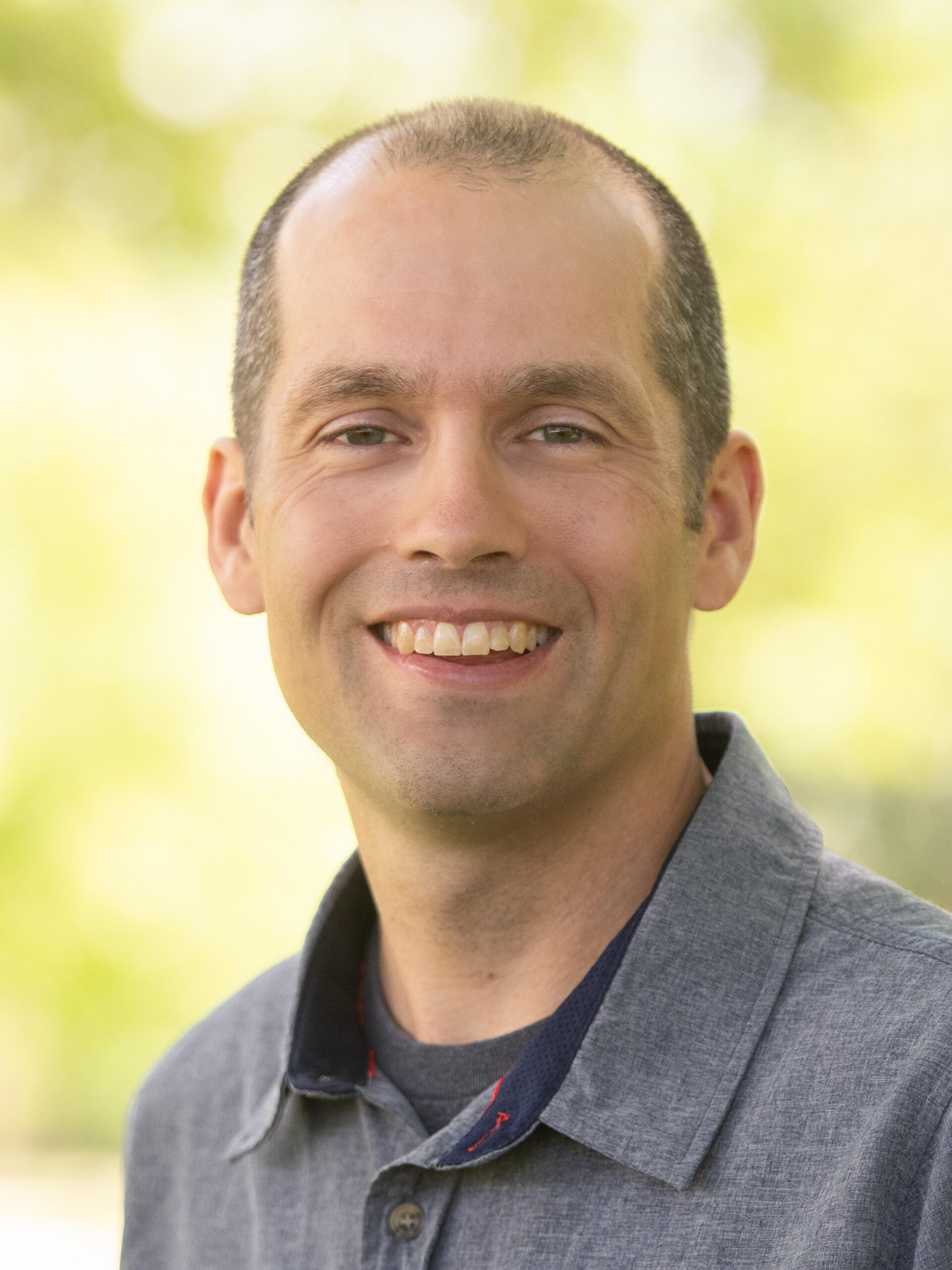 Russell Adrian headshot, with outdoor background