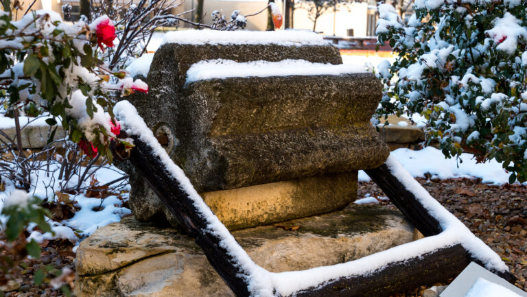 The threshing stone in front of the Ad Building with a dusting of snow and red berries