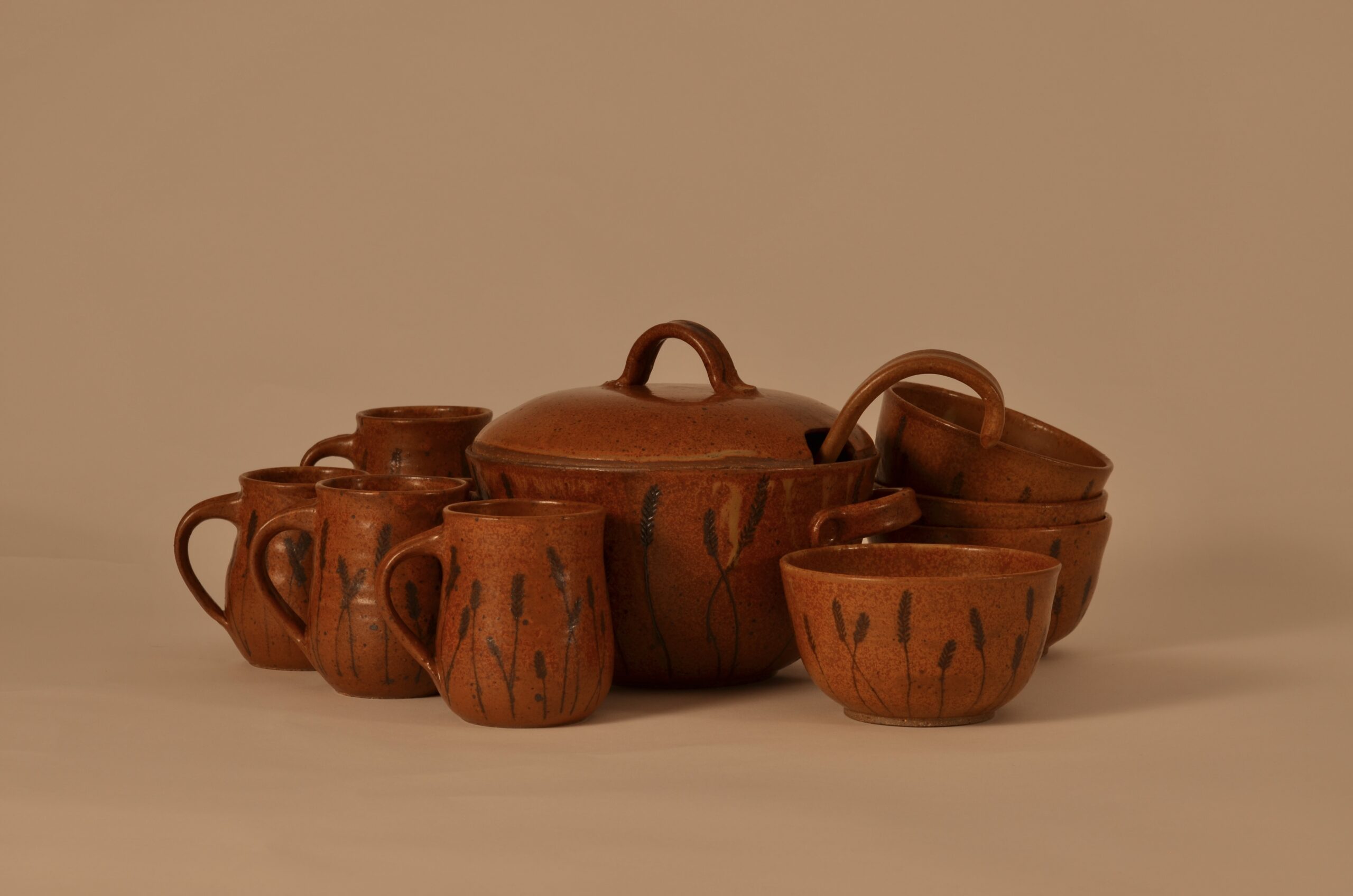 Abby Chappell Deckert's pottery set "Wheat," rust-brown mugs, soup bowls and soup tureen, with wheat stalk motifs