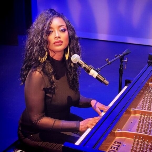 Roz McCommon wearing black, at the piano
