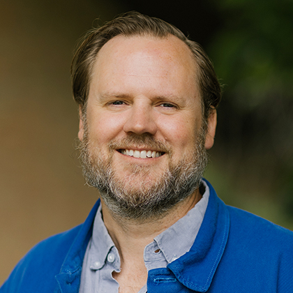 Headshot of Jamie Pitts in blue shirt and blue sweater