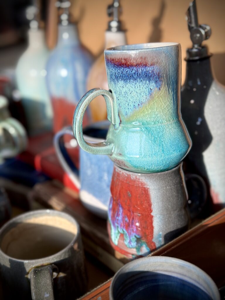 Ceramic mugs, one on top of another, with glazing in blues and reds